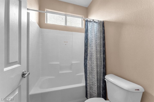 bathroom featuring shower / bath combination with curtain and toilet