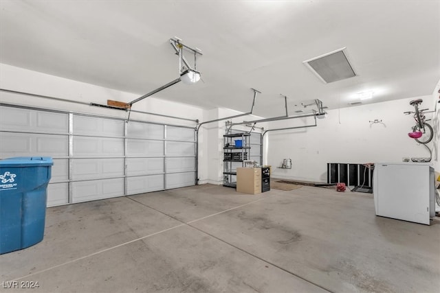 garage with a garage door opener and white refrigerator