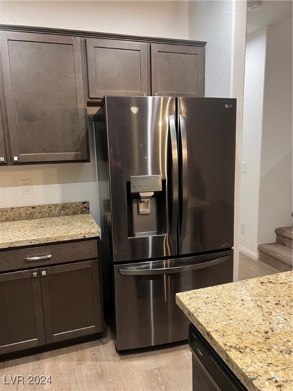 kitchen featuring light stone counters, light hardwood / wood-style floors, dark brown cabinetry, and stainless steel appliances