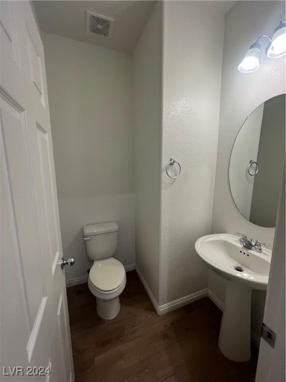 bathroom with wood-type flooring and toilet