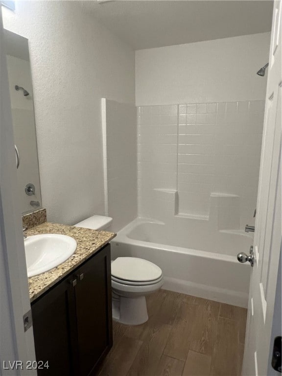 full bathroom featuring wood-type flooring, shower / bathtub combination, vanity, and toilet