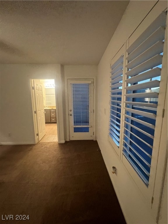 hallway featuring carpet floors and a textured ceiling