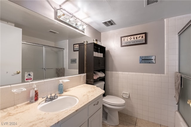 bathroom with tile patterned flooring, tile walls, vanity, and toilet