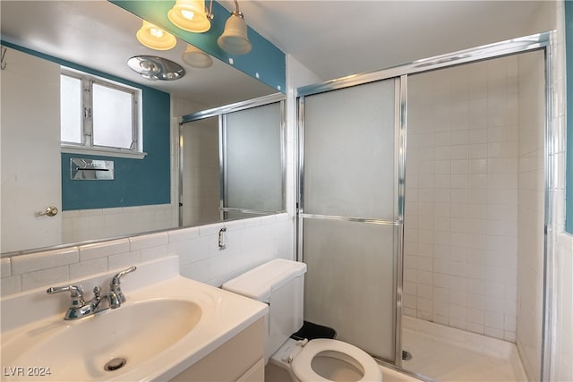 bathroom featuring vanity, tile walls, a shower with shower door, and toilet