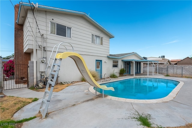 view of pool featuring a water slide and a patio area