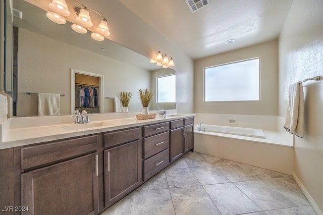 bathroom featuring tile patterned floors, a bathing tub, and vanity