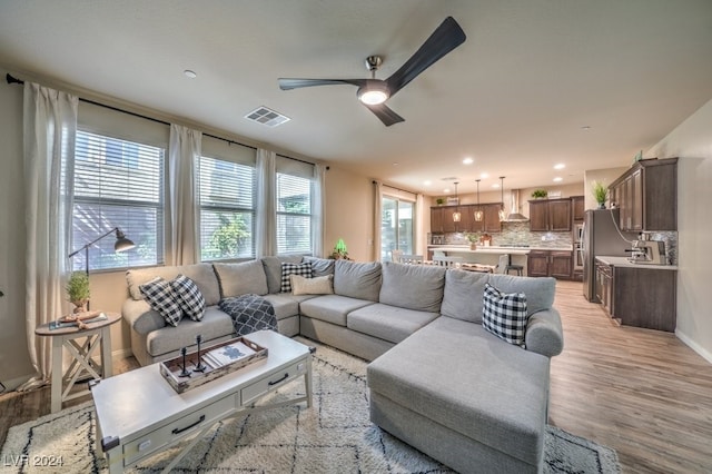 living room featuring light hardwood / wood-style floors and ceiling fan