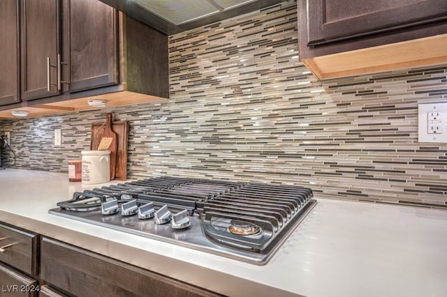 kitchen featuring dark brown cabinetry, stainless steel gas stovetop, and backsplash