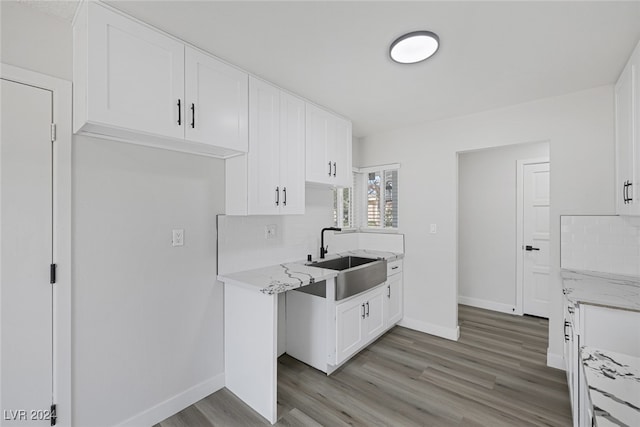 kitchen with light hardwood / wood-style flooring, white cabinetry, and sink