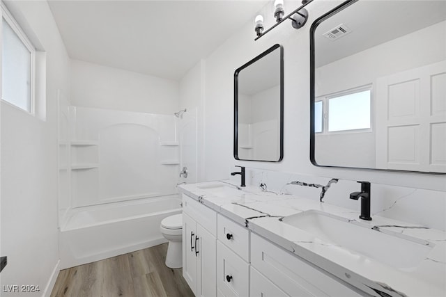 full bathroom featuring vanity, toilet, wood-type flooring, and bathing tub / shower combination