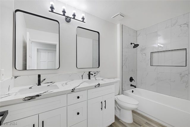 full bathroom featuring vanity, toilet, tiled shower / bath combo, and wood-type flooring