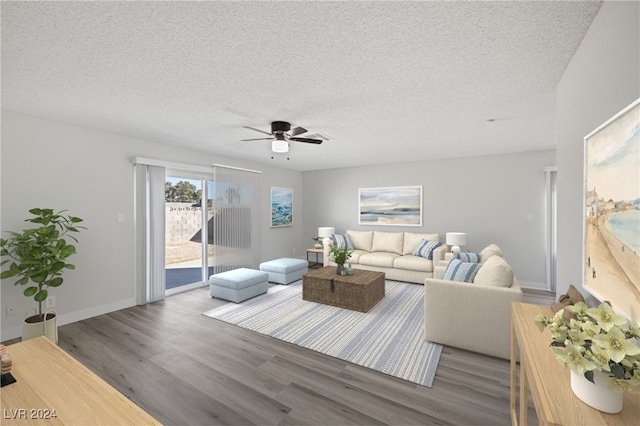 living room with ceiling fan, hardwood / wood-style flooring, and a textured ceiling