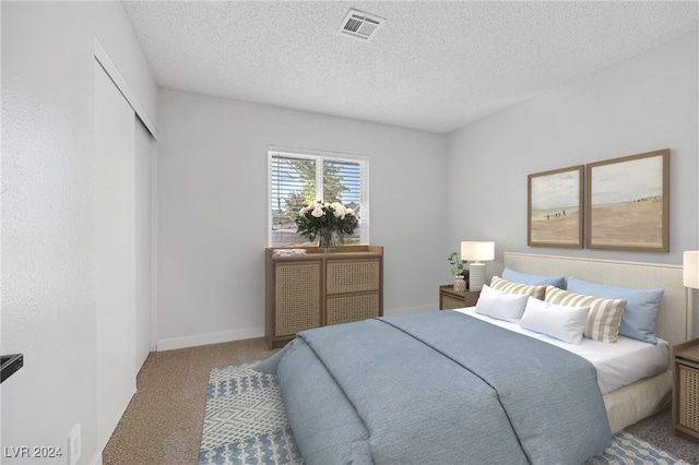 carpeted bedroom with a closet and a textured ceiling