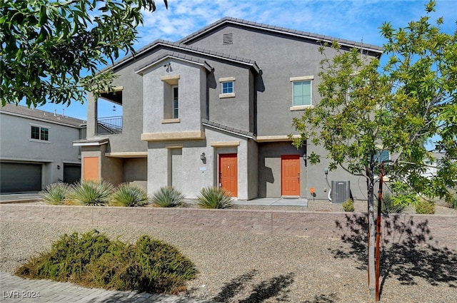 view of front of property featuring a garage and central AC