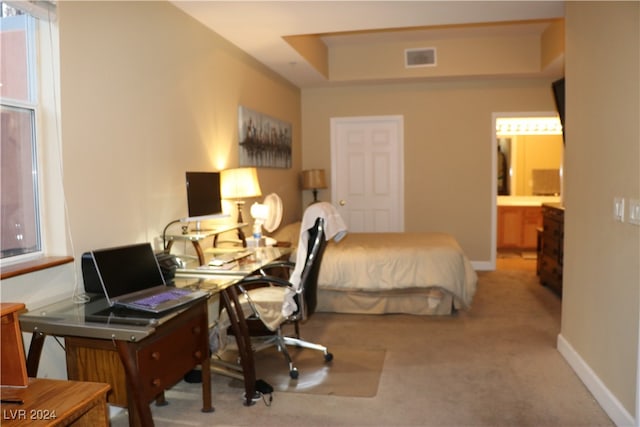 bedroom featuring light carpet and ensuite bathroom