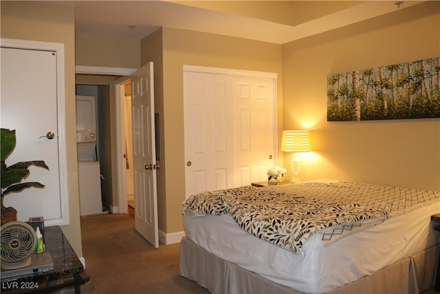 carpeted bedroom with stacked washer and clothes dryer and a closet