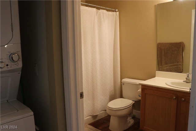 bathroom with stacked washer / dryer, vanity, toilet, and a shower with shower curtain