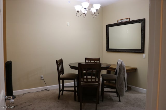 carpeted dining room featuring a notable chandelier