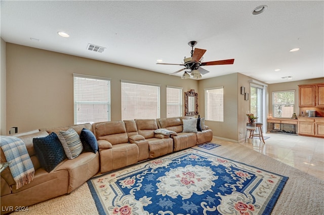 living room with ceiling fan and a textured ceiling