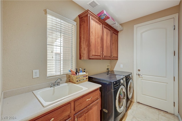 washroom featuring light tile patterned flooring, washer and dryer, sink, and cabinets