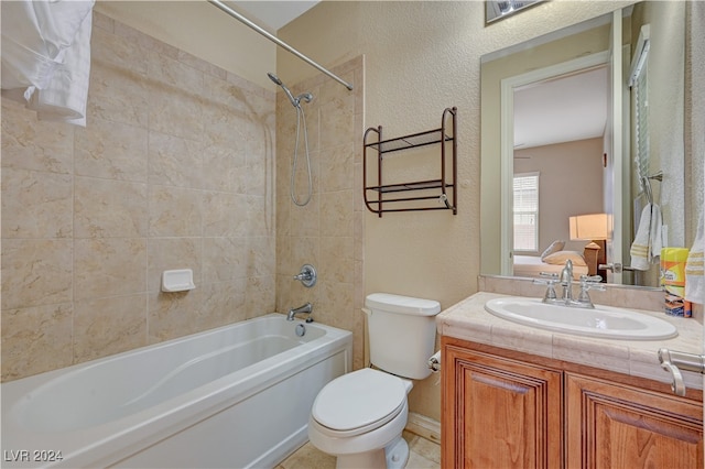 full bathroom with tiled shower / bath, vanity, and toilet