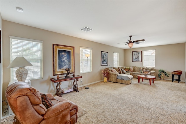 living room with carpet floors, ceiling fan, and a healthy amount of sunlight