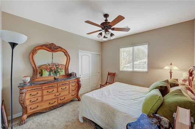 carpeted bedroom with ceiling fan and a closet