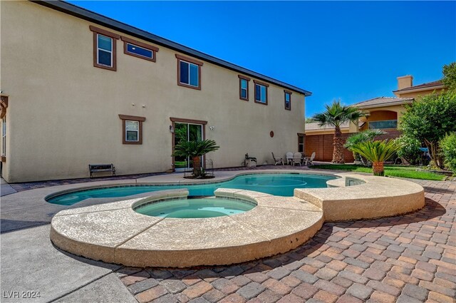 view of pool featuring an in ground hot tub and a patio area