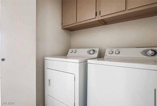 clothes washing area with washer and clothes dryer and cabinet space