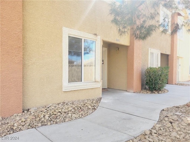 doorway to property featuring stucco siding