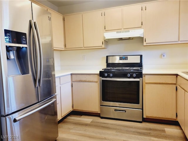 kitchen featuring under cabinet range hood, light countertops, light wood-type flooring, and appliances with stainless steel finishes