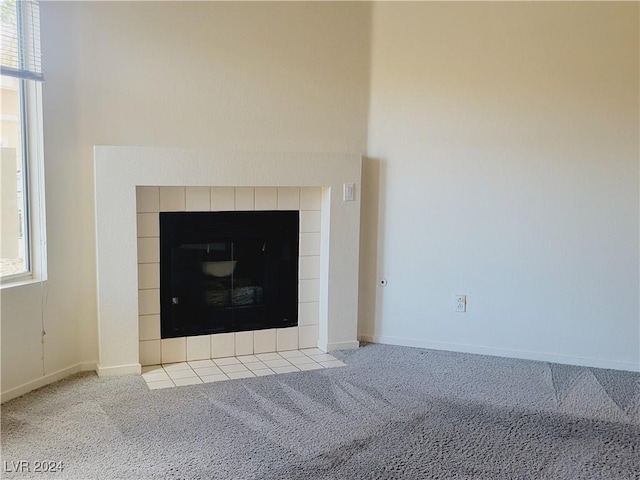 details with baseboards, carpet flooring, and a tile fireplace