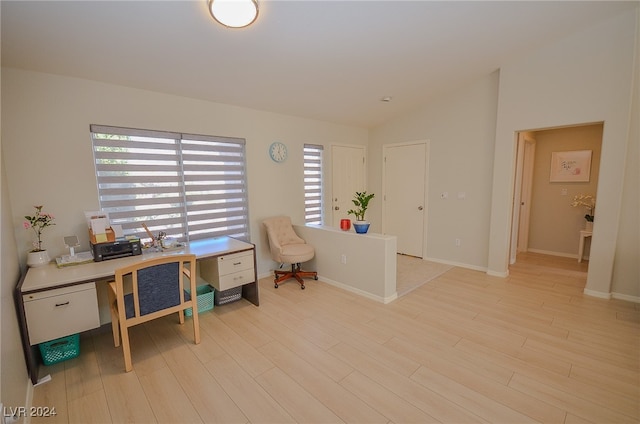 home office with vaulted ceiling and light hardwood / wood-style flooring