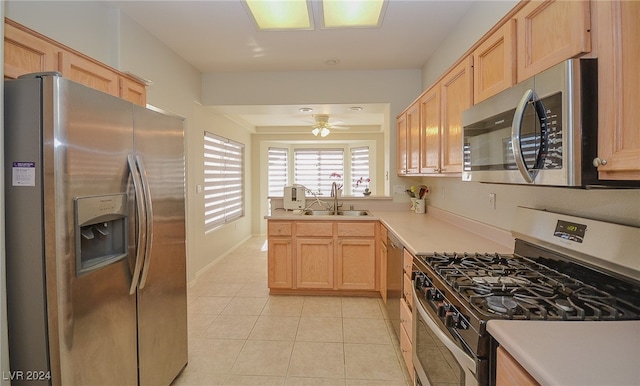 kitchen featuring light tile patterned floors, light brown cabinets, appliances with stainless steel finishes, and sink