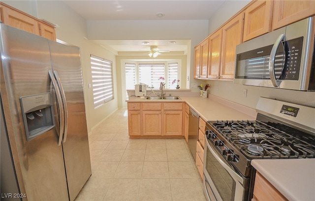 kitchen featuring stainless steel appliances, light brown cabinetry, and sink