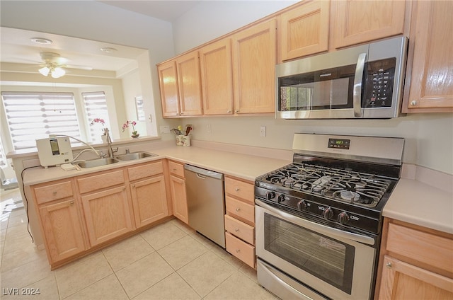 kitchen featuring light brown cabinets, sink, kitchen peninsula, appliances with stainless steel finishes, and light tile patterned floors