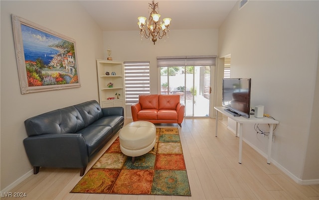 living room featuring a notable chandelier and light wood-type flooring