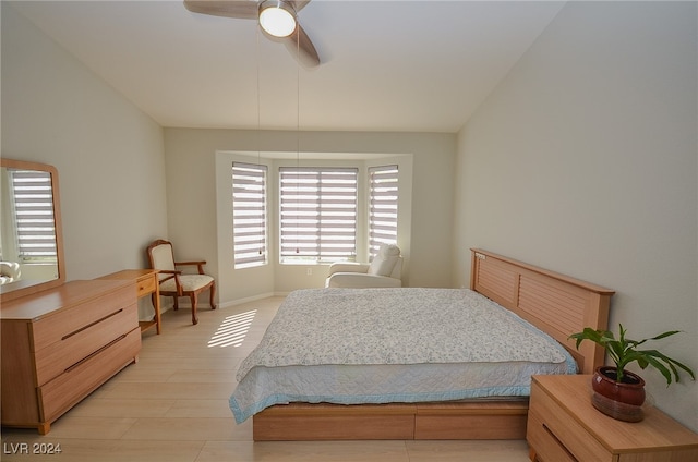 bedroom with ceiling fan, lofted ceiling, and light hardwood / wood-style floors