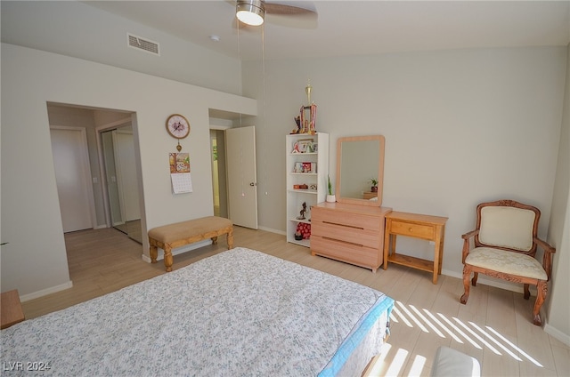 bedroom with ceiling fan, light wood-type flooring, a closet, and lofted ceiling