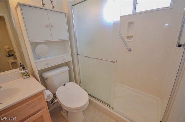 bathroom with vanity, tile patterned flooring, toilet, and a shower with door