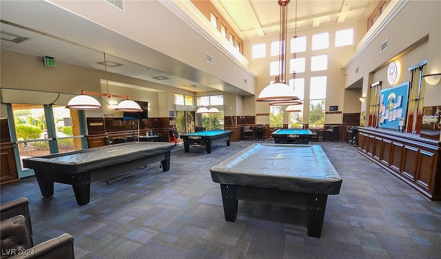 game room with a towering ceiling, pool table, and carpet