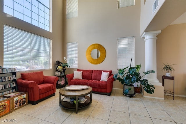 tiled living room featuring ornate columns and a high ceiling