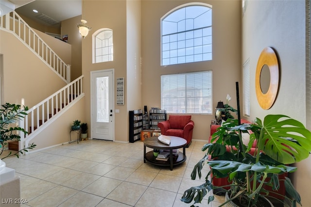 foyer entrance featuring light tile patterned flooring and a towering ceiling