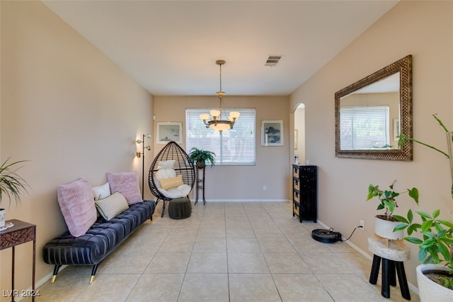 living area with an inviting chandelier, light tile patterned floors, and a healthy amount of sunlight