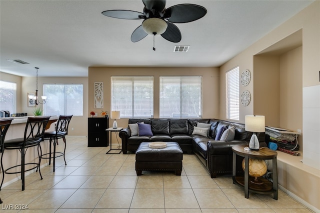 tiled living room featuring ceiling fan with notable chandelier and a healthy amount of sunlight