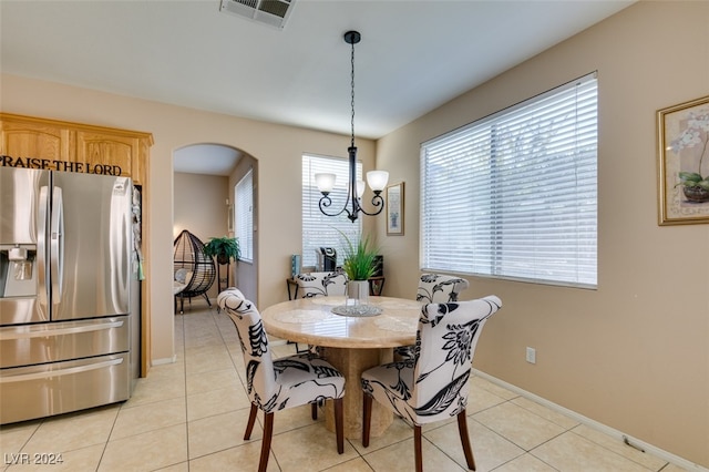 tiled dining room featuring an inviting chandelier