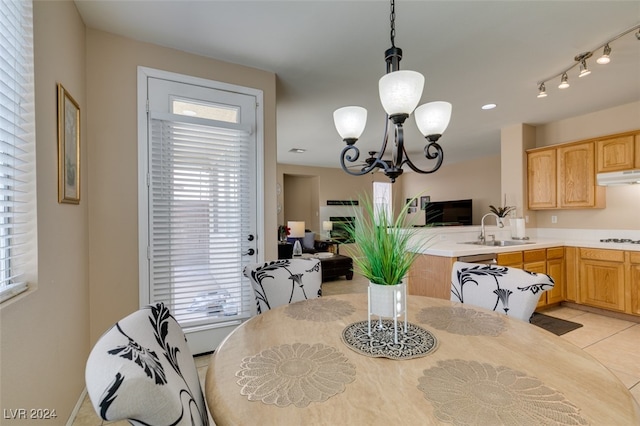 tiled dining space with an inviting chandelier and sink