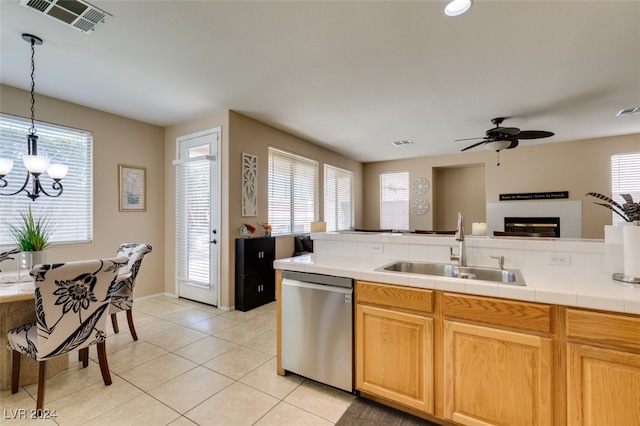 kitchen featuring ceiling fan with notable chandelier, sink, a wealth of natural light, and stainless steel dishwasher