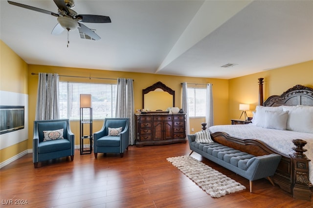 bedroom with multiple windows, ceiling fan, and dark hardwood / wood-style floors