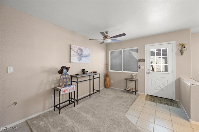 interior space featuring light tile patterned flooring, ceiling fan, and radiator